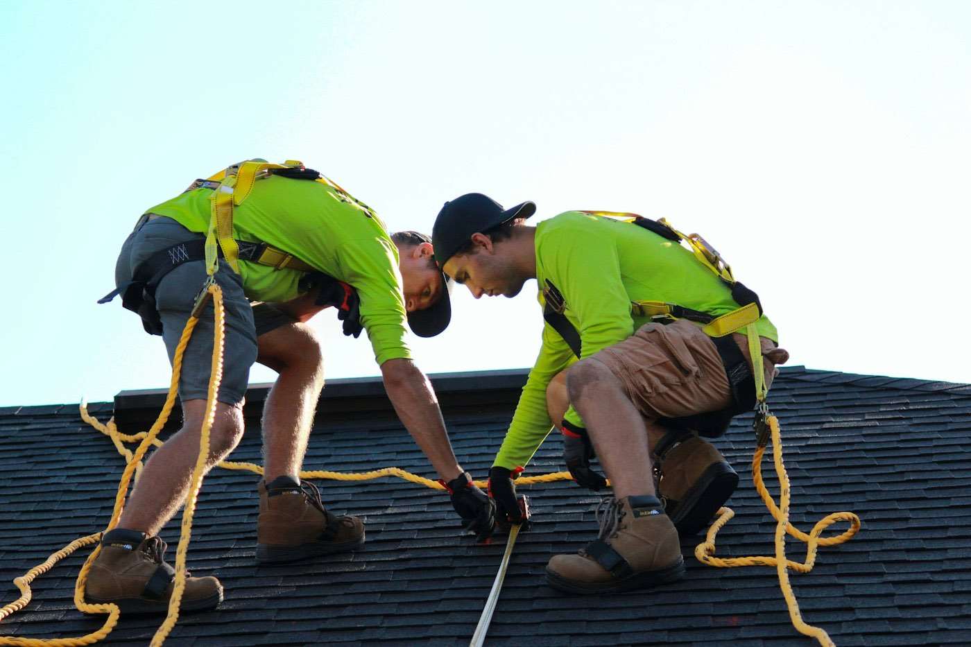 Roofing crew laying shingles on a residential slope