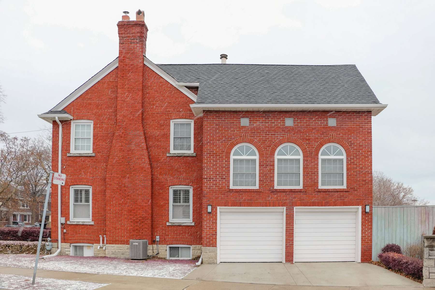 Red brick house with snow banked along the roof and eaves