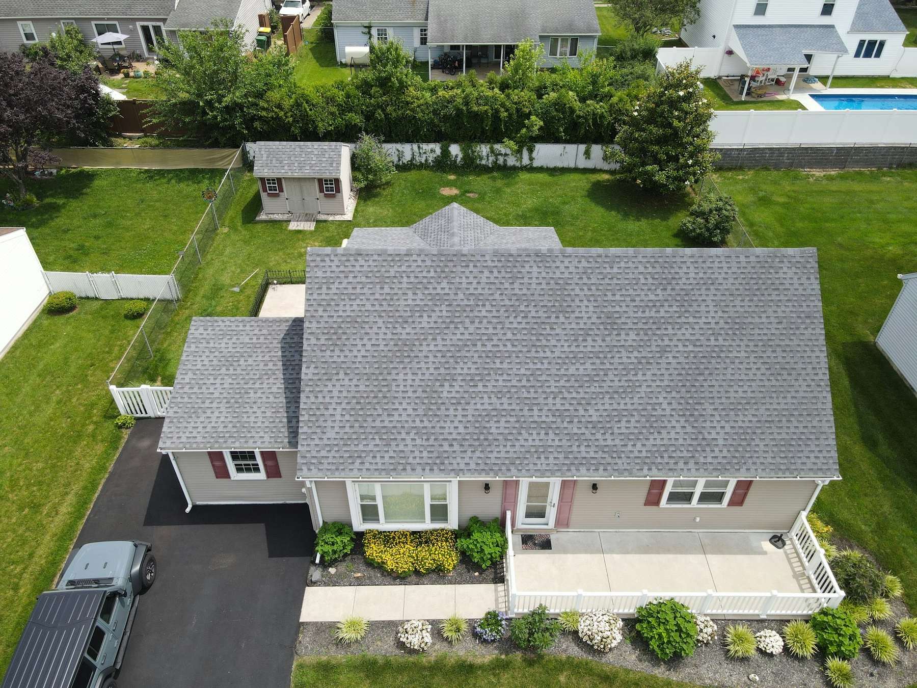 Suburban house with a new grey shingle roof seen from above