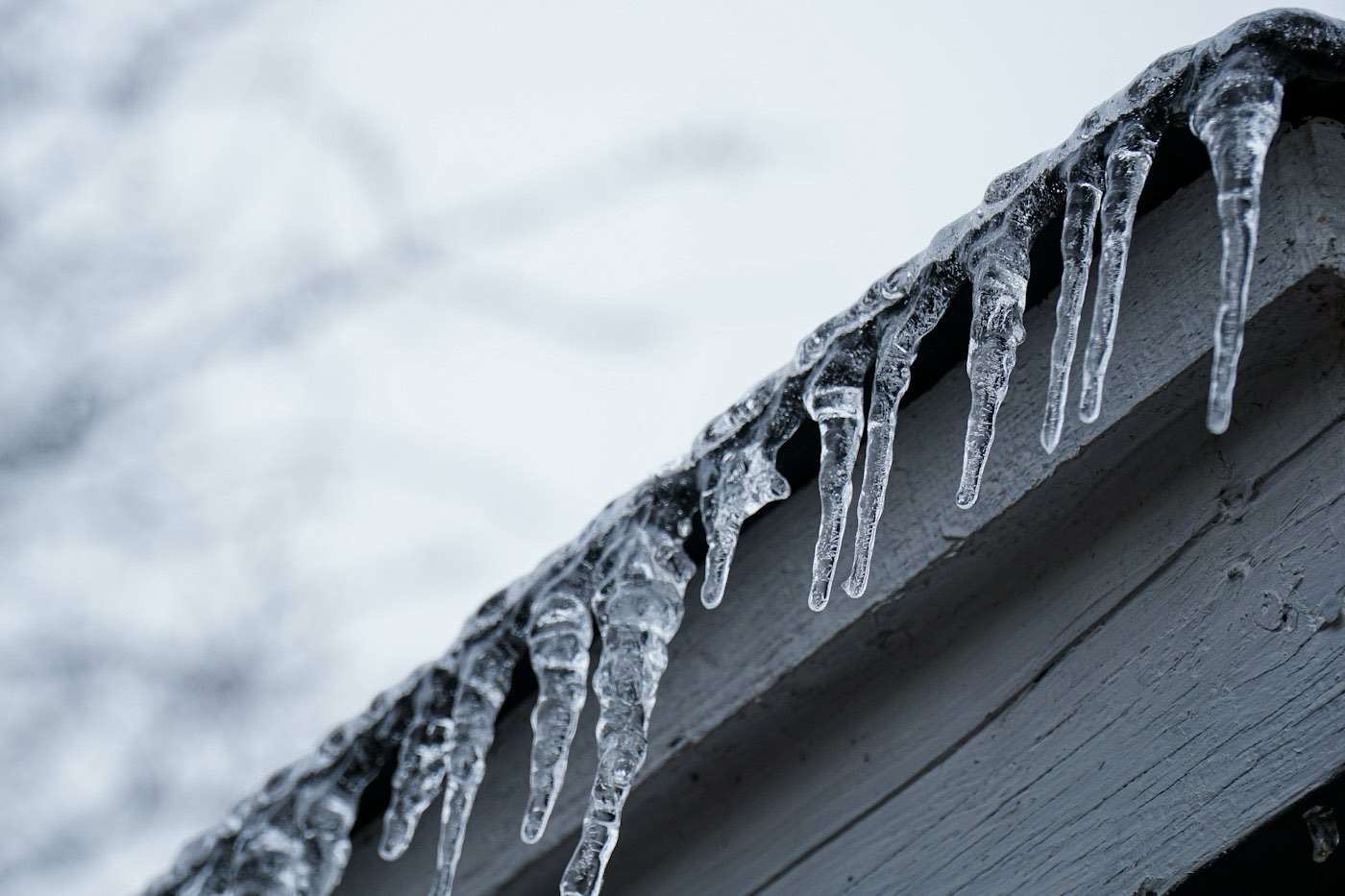 Close view of icicles forming along a roof edge