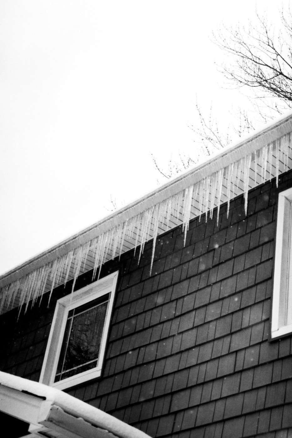 Icicles hanging from a house eave, a sign of ice damming