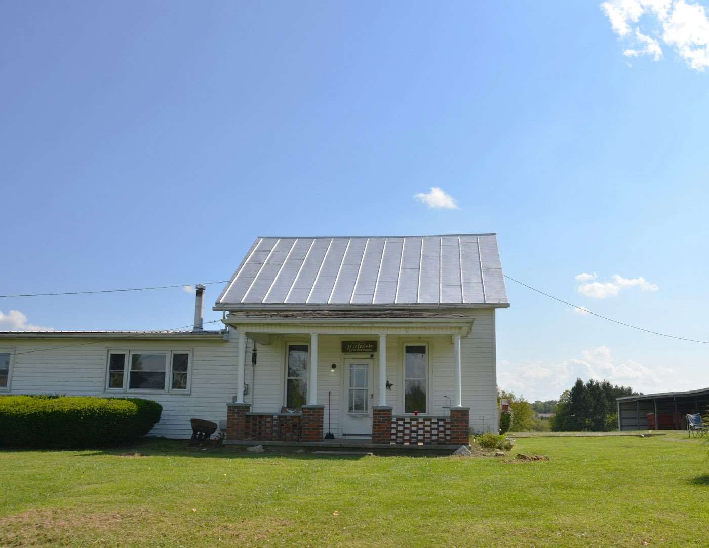 White farmhouse with a standing-seam metal roof